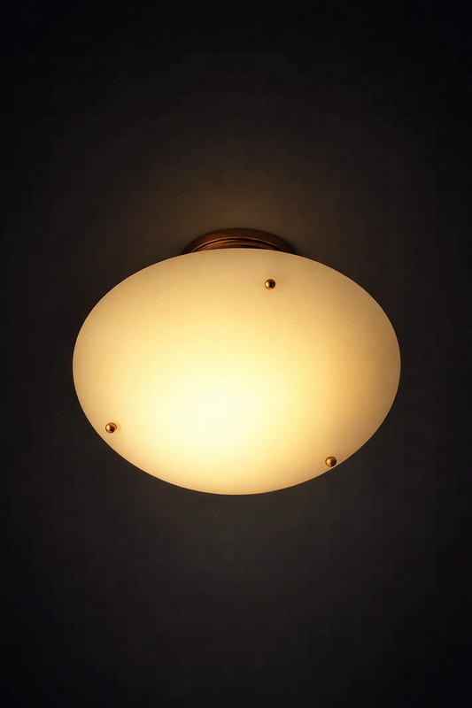 Ceiling light fixture with a white glass shade on a black background