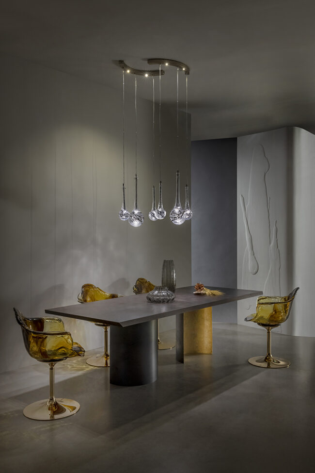 Modern dining room with a stylish chandelier, table, and chairs.