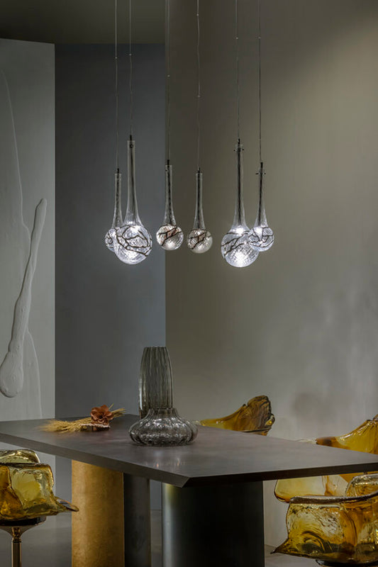 Modern pendant lights hanging above a table with a neutral background