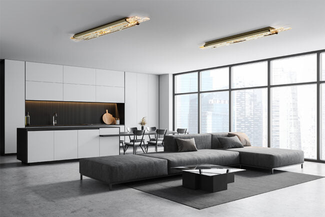 Modern living room with a gray sectional sofa, kitchen, and large windows.