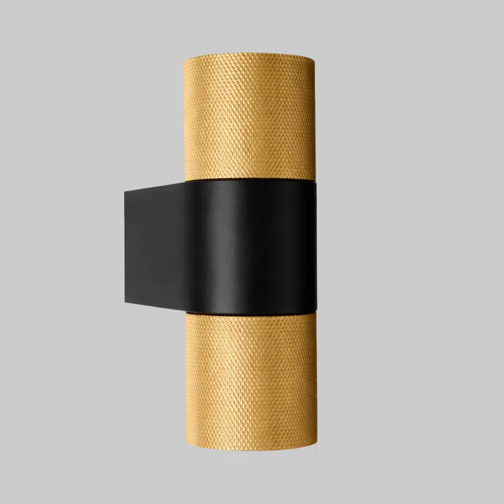 Wall sconce with gold textured finish and black accent on a white background
