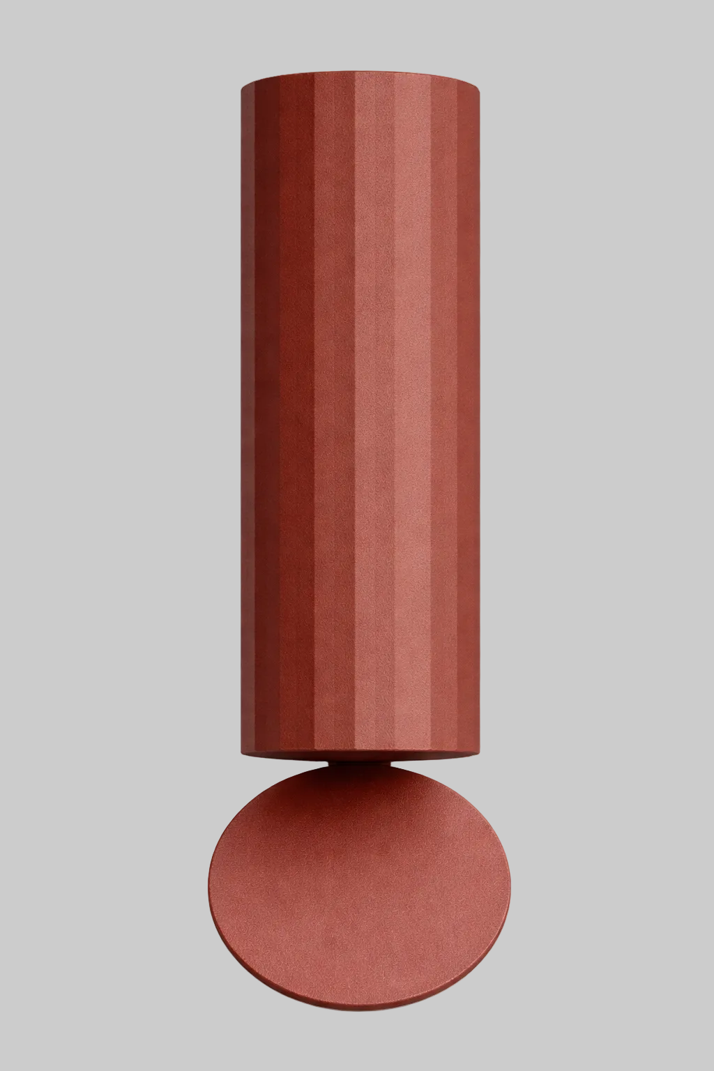 Cylindrical wall sconce with a round base on a white background