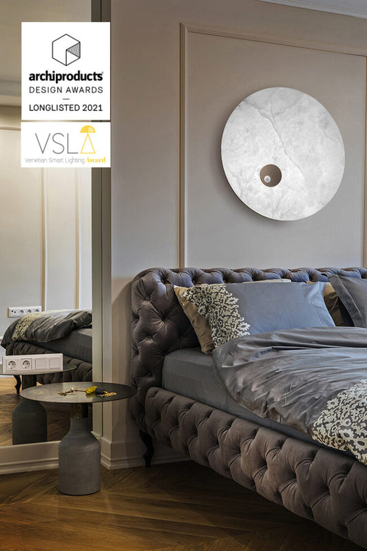 Modern bedroom with a bed, lamp, and decor elements, featuring the Archiproducts Design Awards 2021 longlisted VSL logo.