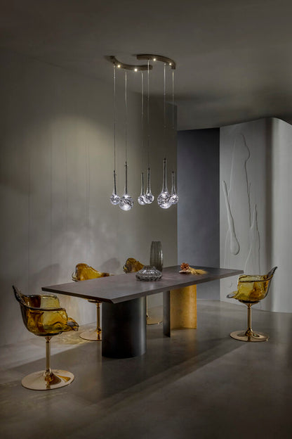 Modern dining room with a stylish chandelier, table, and chairs.