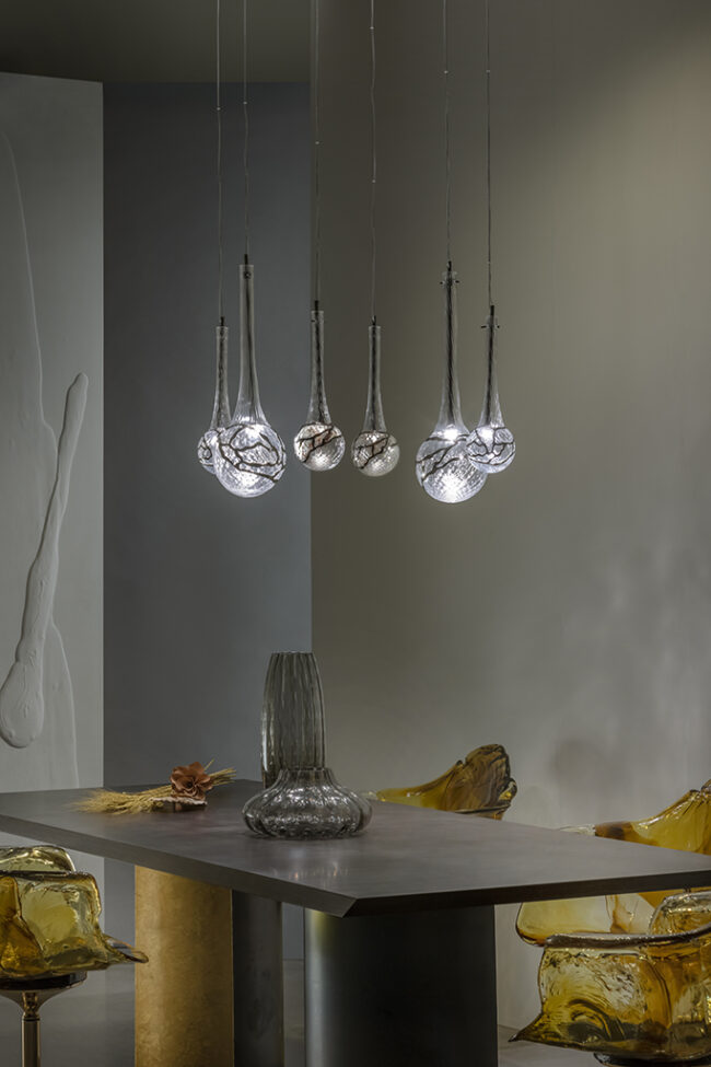 Modern pendant lights hanging above a table with a neutral background