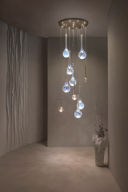 Modern chandelier with glass shades in a dimly lit room.