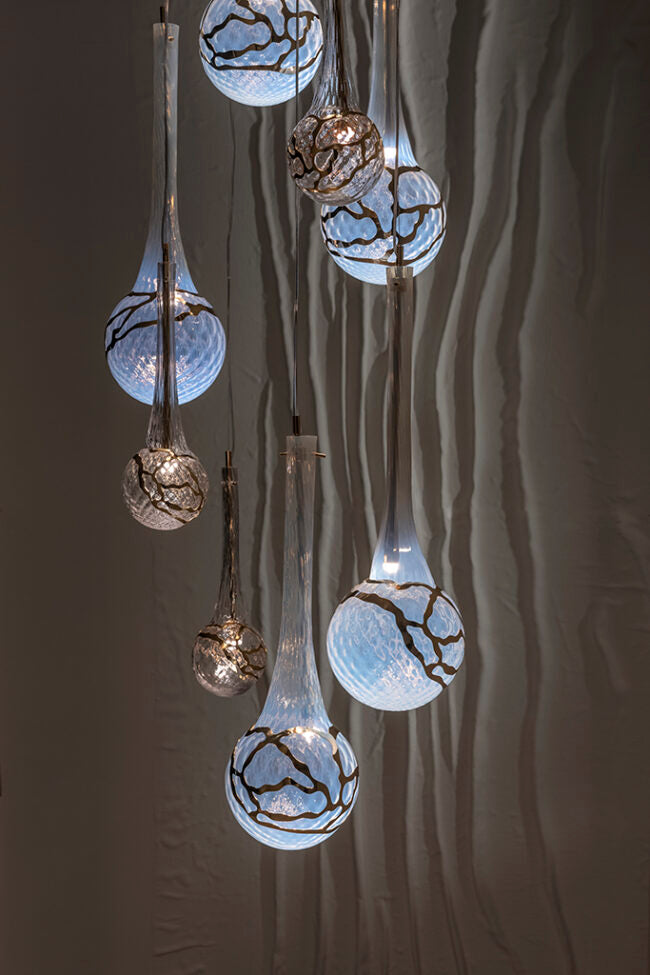 Decorative hanging lights with glass bulbs on a textured wall background