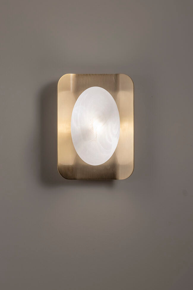 Square wall light fixture with brass frame and white glass on a gray background