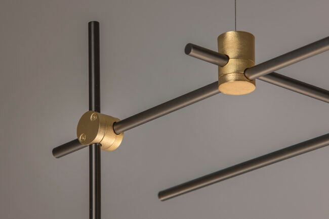 Modern pendant light with gold and black design on a gray background