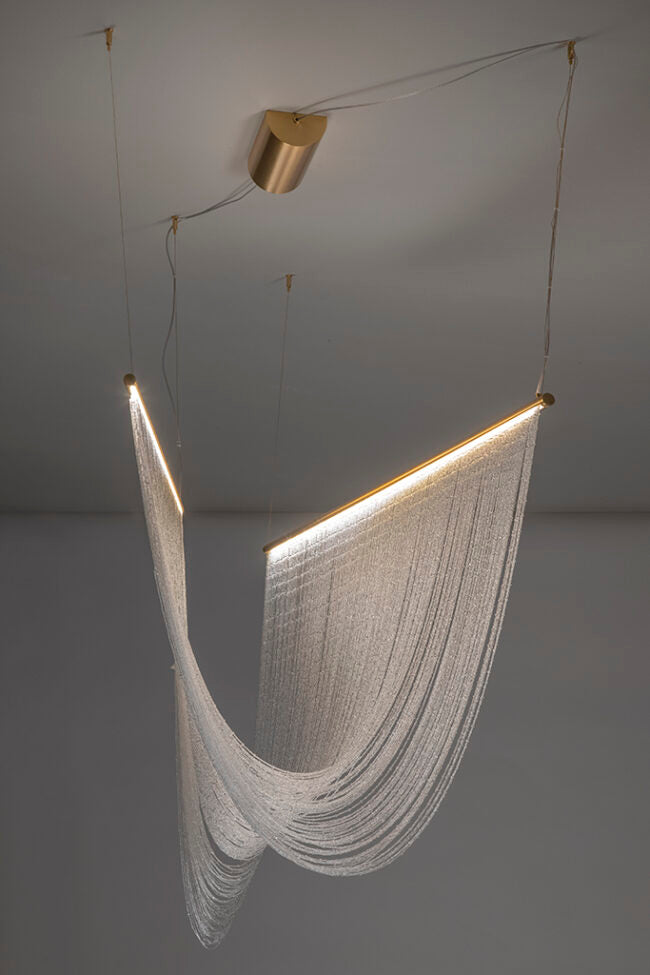 Modern hanging light fixture with a soft glow on a neutral background