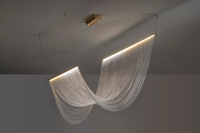 Modern chandelier with white fabric-like design hanging from a ceiling