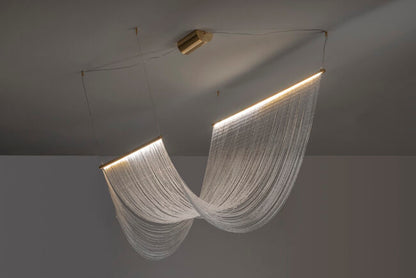 Modern chandelier with white fabric-like design hanging from a ceiling