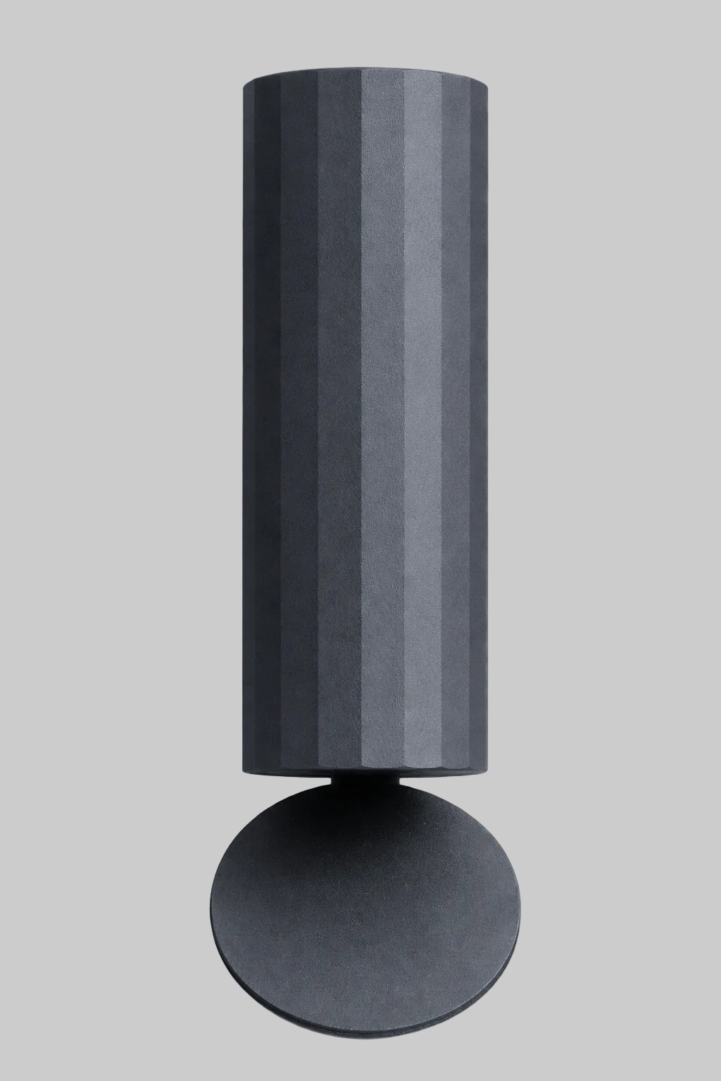 Black cylindrical wall light fixture on a white background