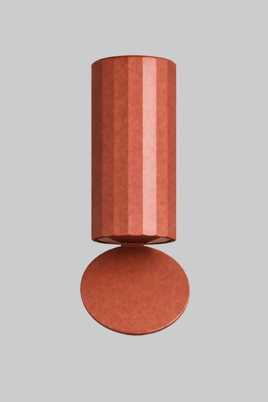 Cylindrical terracotta-colored object on a white background