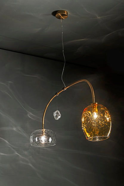 Modern pendant light with glass shades and gold accents on a dark background
