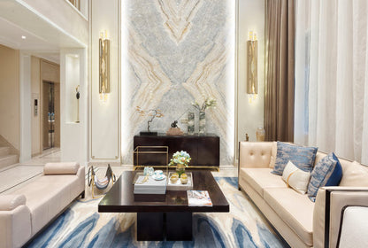 Modern living room with marble wall, beige sofa, and decorative elements.