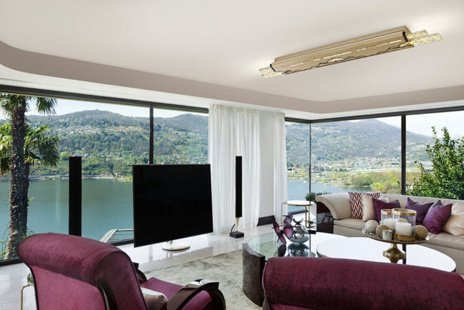 Modern living room with a large TV, comfortable seating, and scenic views.