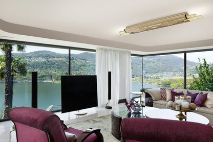 Modern living room with a large TV, comfortable seating, and scenic views.