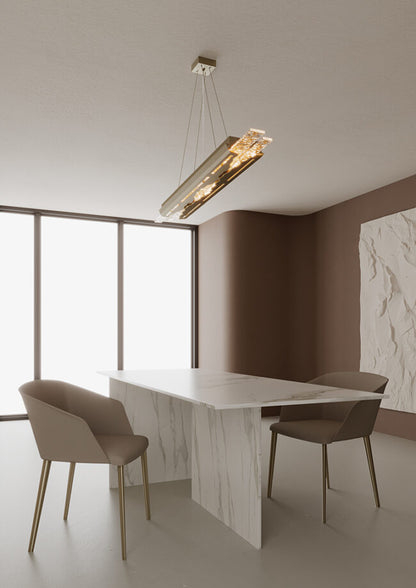 Modern dining area with a white marble table and chairs, featuring a ceiling light fixture.