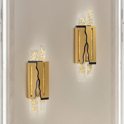 Two modern wall sconces with gold and glass design on a neutral wall.