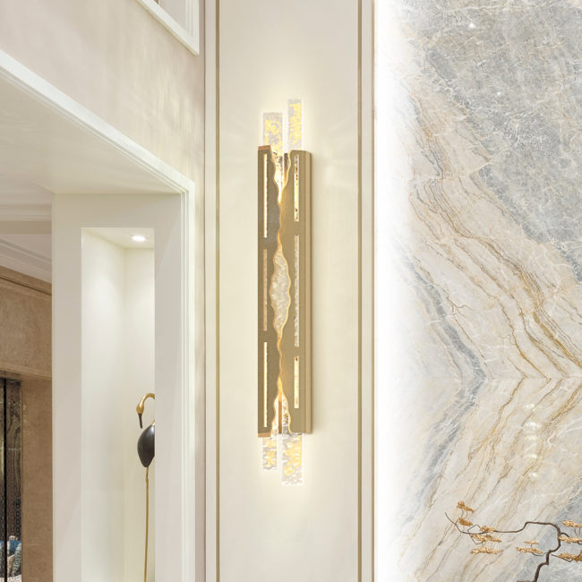 Gold wall sconce on a marble wall in a modern interior setting