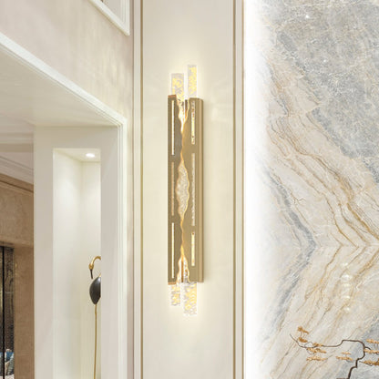 Gold wall sconce on a marble wall in a modern interior setting