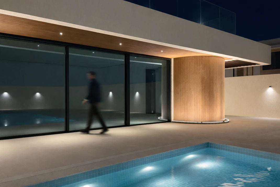 Modern building exterior with a pool at night