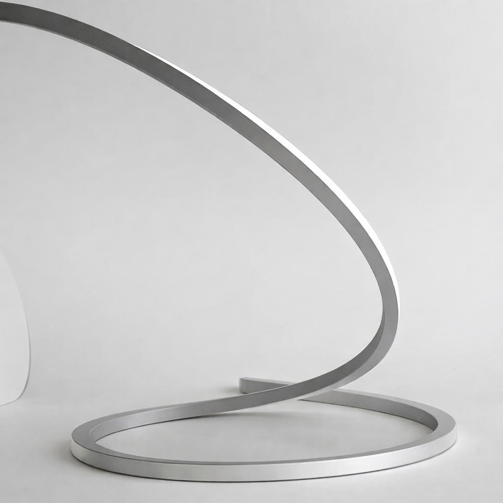 Modern metal sculpture with a curved design on a white background