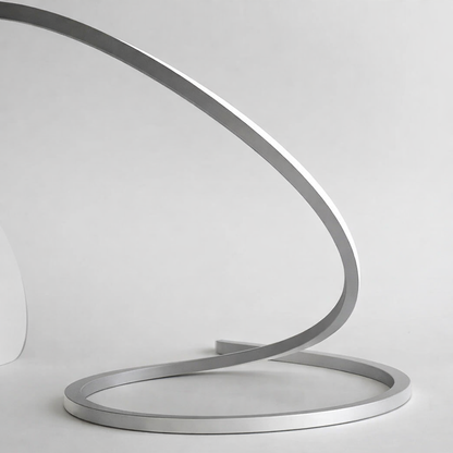 Modern metal sculpture with a curved design on a white background