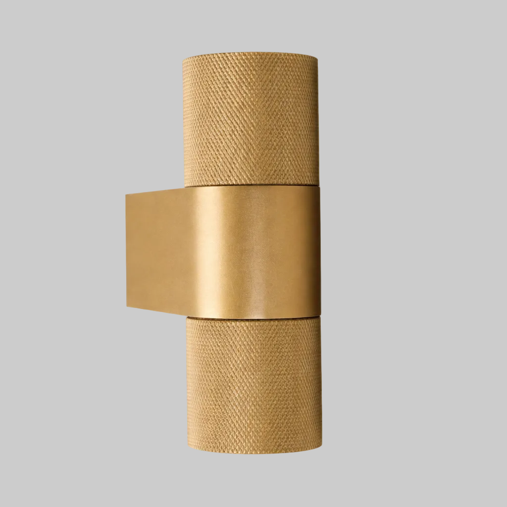 Gold wall sconce with textured design on a light gray background
