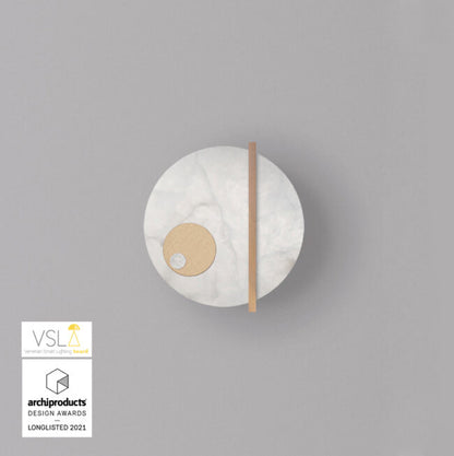 Round wall light fixture on a gray background with VSLA and archiproducts Design Awards logos.
