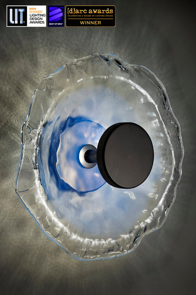 Decorative light fixture with blue and white design on a gray background, featuring awards logos.