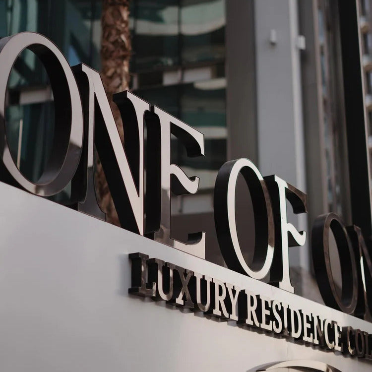 One of One Luxury residence complex sign with 'ONE OF' and 'LUXURY RESIDENCE' text.